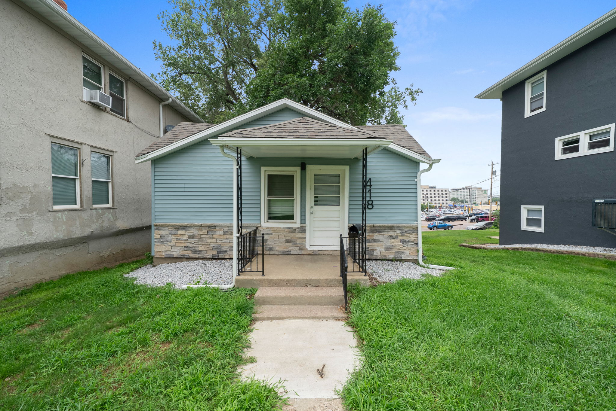 A two-story residential home with blue siding and white trim, featuring a front porch and an attached single-car garage, located at 1409 S Norton Ave, Sioux Falls, SD.