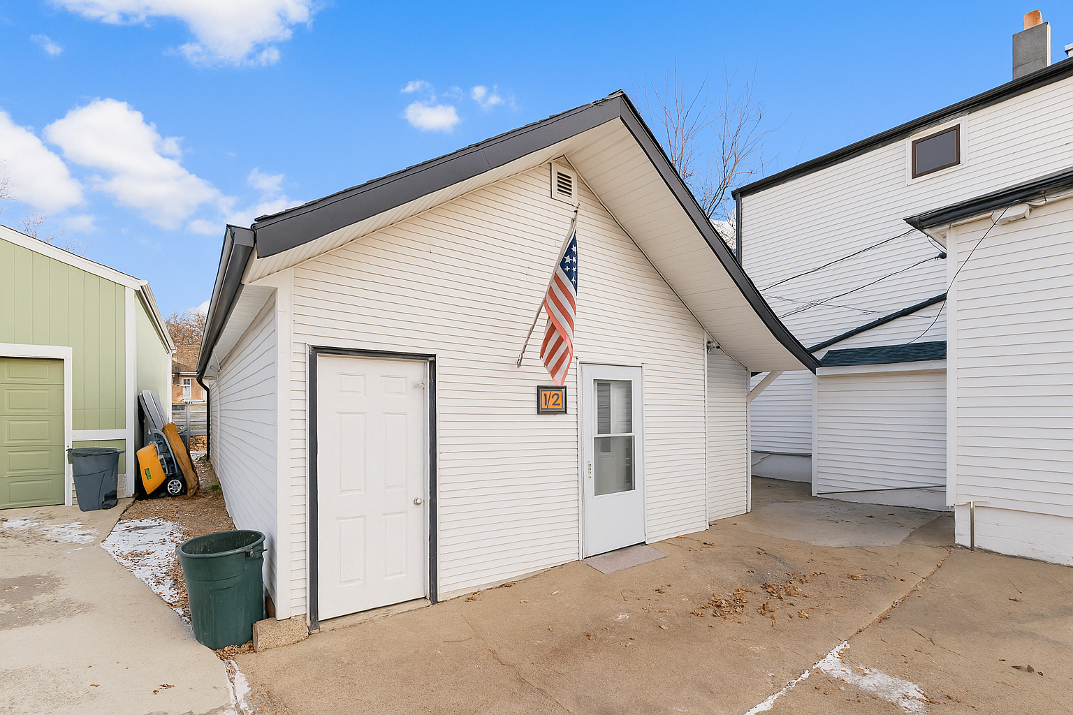 A two-story residential home with blue siding and white trim, featuring a front porch and an attached single-car garage, located at 1409 S Norton Ave, Sioux Falls, SD.