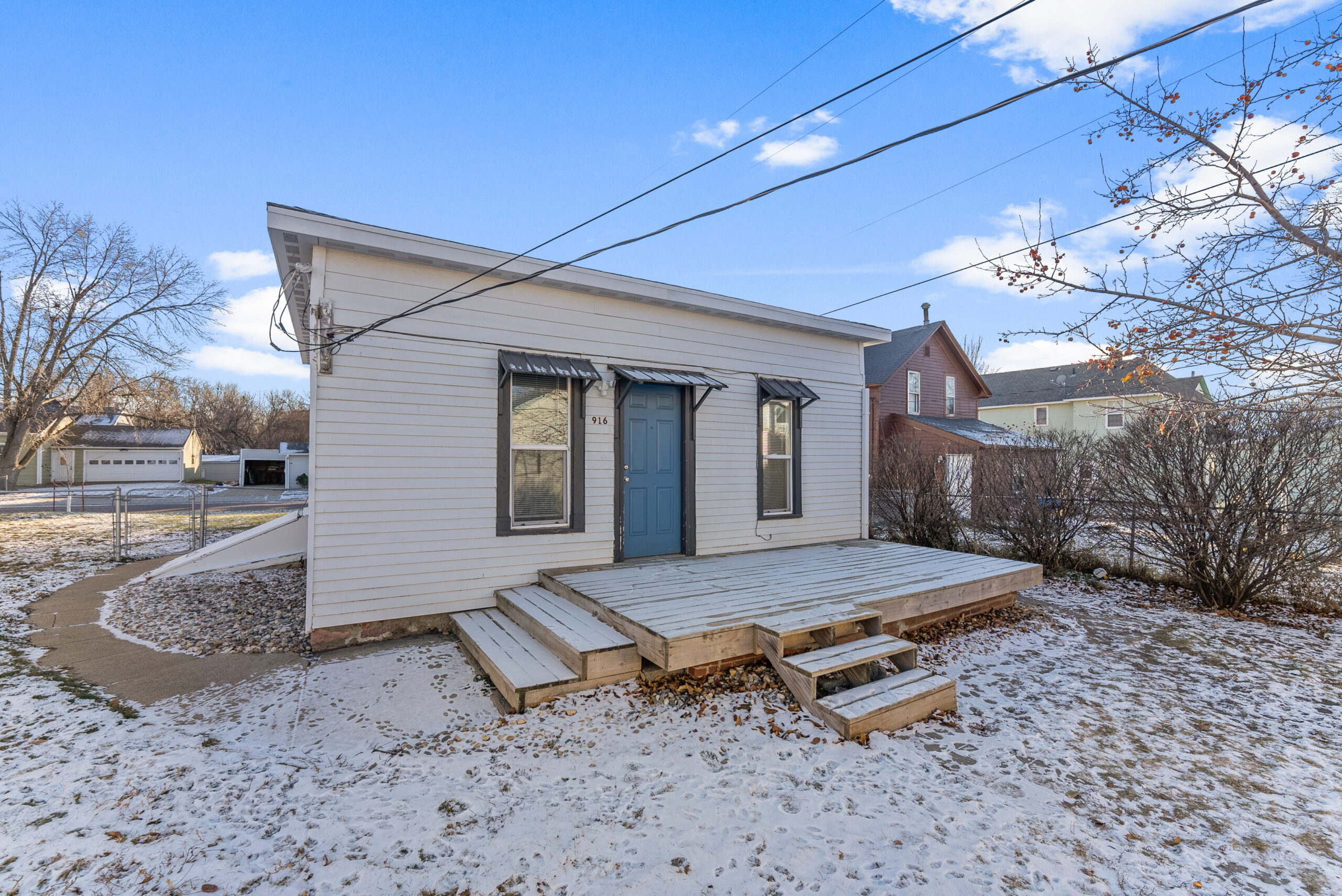 A two-story residential home with blue siding and white trim, featuring a front porch and an attached single-car garage, located at 1409 S Norton Ave, Sioux Falls, SD.