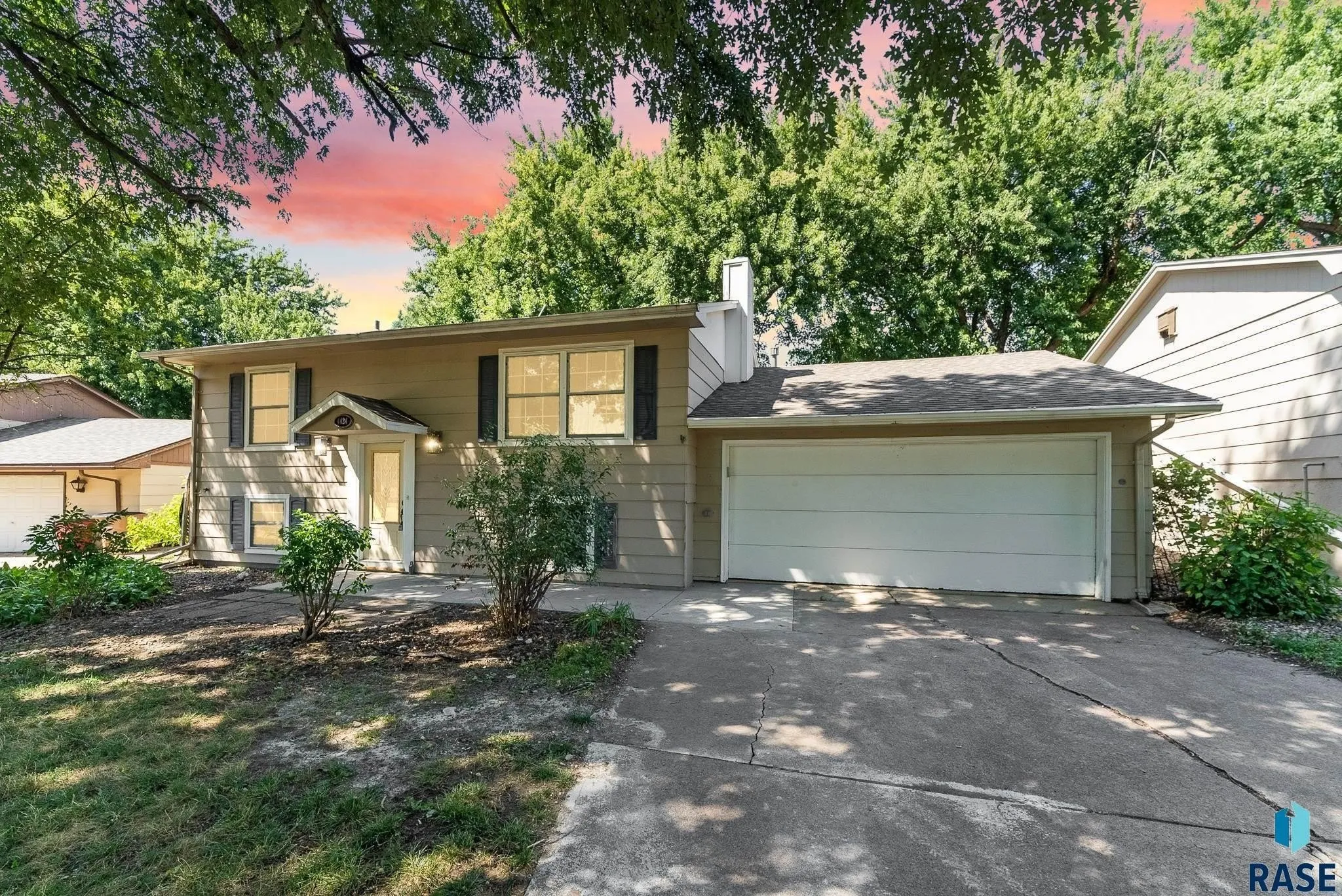 A two-story residential home with blue siding and white trim, featuring a front porch and an attached single-car garage, located at 1409 S Norton Ave, Sioux Falls, SD.