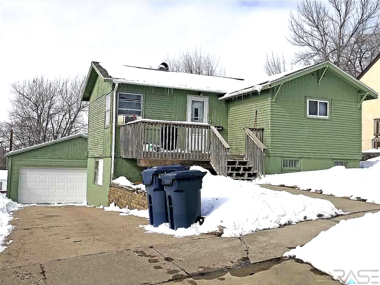 A two-story residential home with blue siding and white trim, featuring a front porch and an attached single-car garage, located at 1409 S Norton Ave, Sioux Falls, SD.
