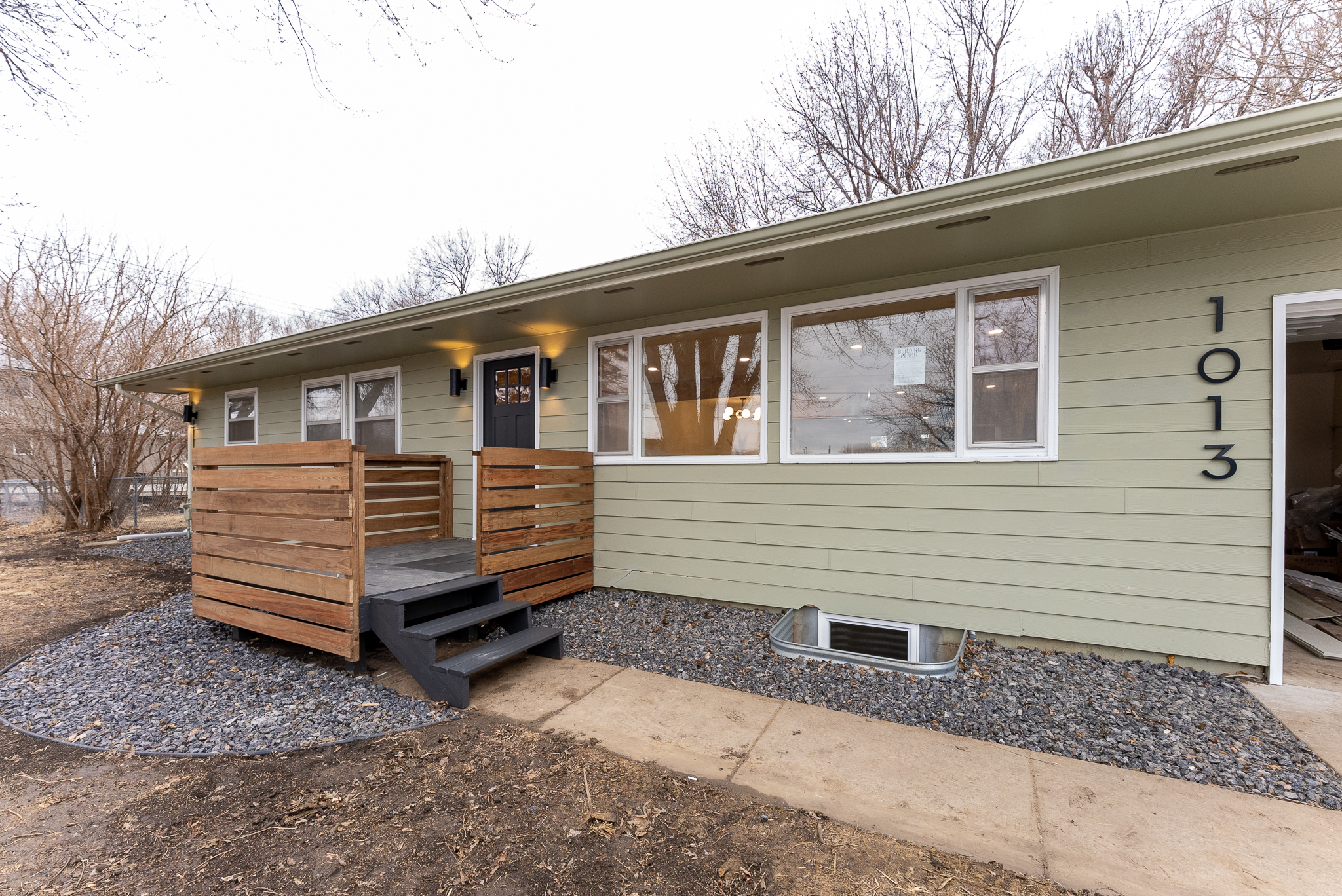 A quaint Cape Cod-style home with beige siding and white window frames, nestled among mature trees in a lush green lawn, located at 2201 S Euclid Ave, Sioux Falls, SD.