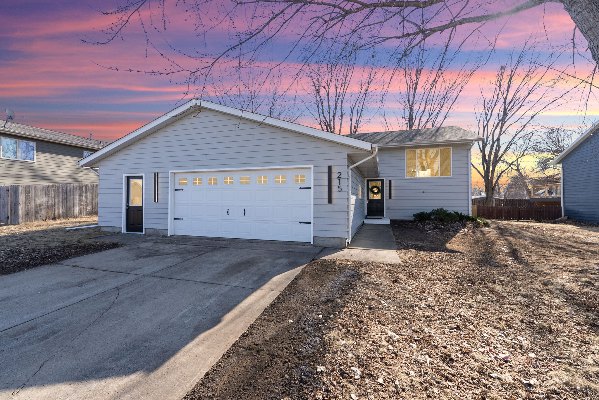 10-web-or-mls-DSC05125DTE A quaint Cape Cod-style home with beige siding and white window frames, nestled among mature trees in a lush green lawn, located at 2201 S Euclid Ave, Sioux Falls, SD.